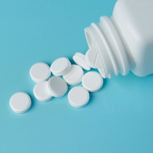 Image of pill tablets spilling out of a bottle